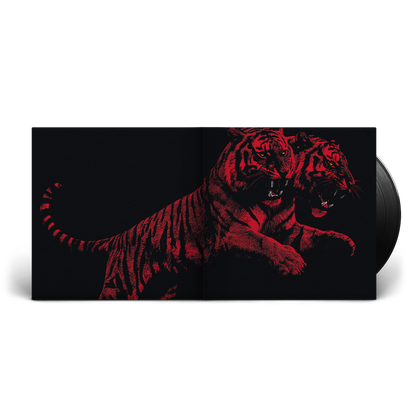 A vinyl record partially pulled from its sleeve, showing a black-and-red graphic of two roaring tigers on the cover against a white background.